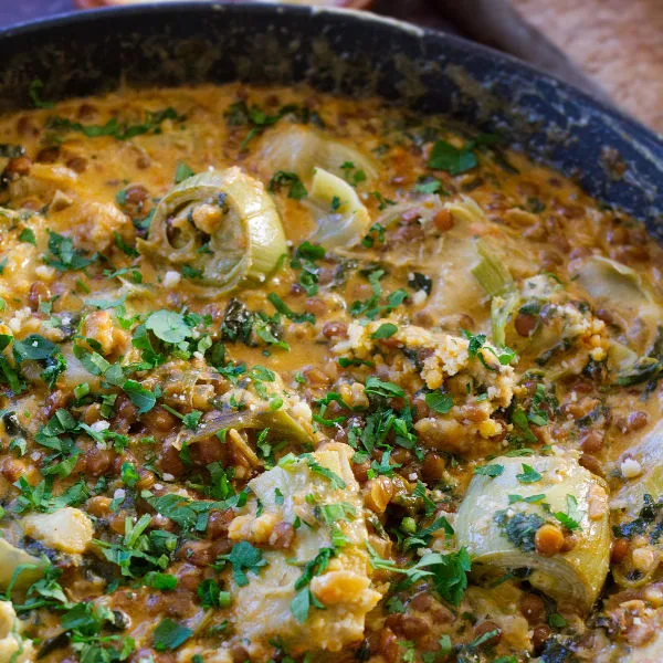 A pan of creamy artichoke casserole with spinach and paprika.