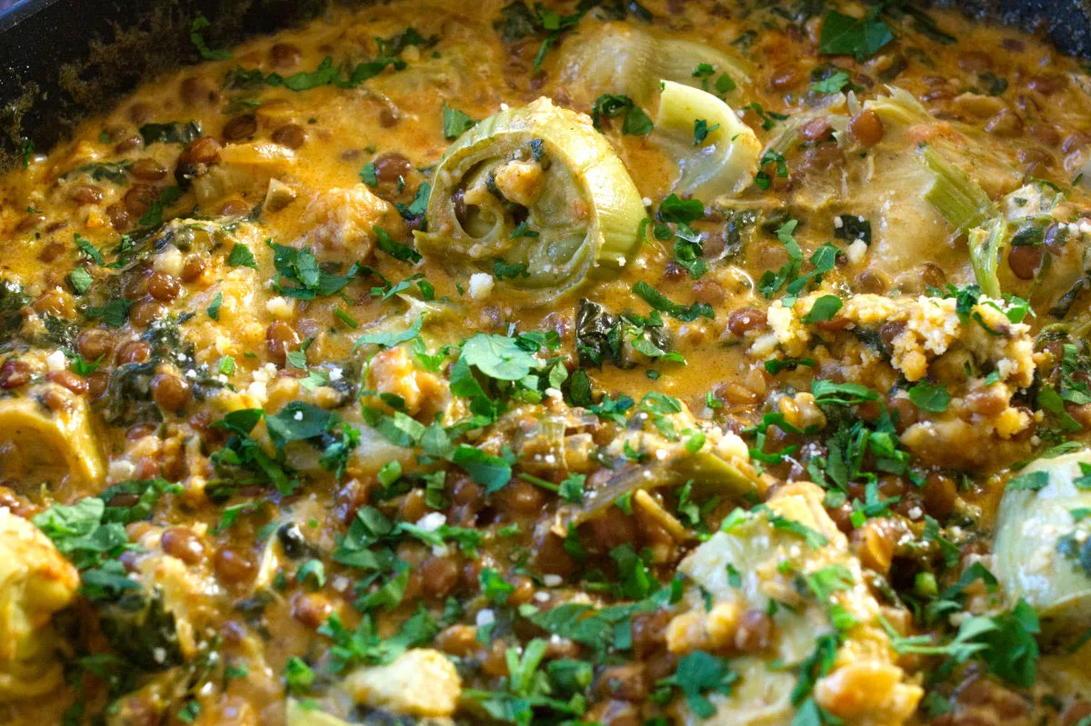 A pan of creamy artichoke casserole with spinach and paprika.