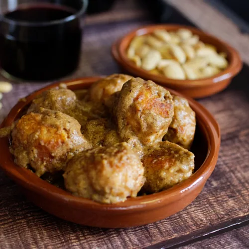 A small tapas serving of chicken meatballs with almond sauce.