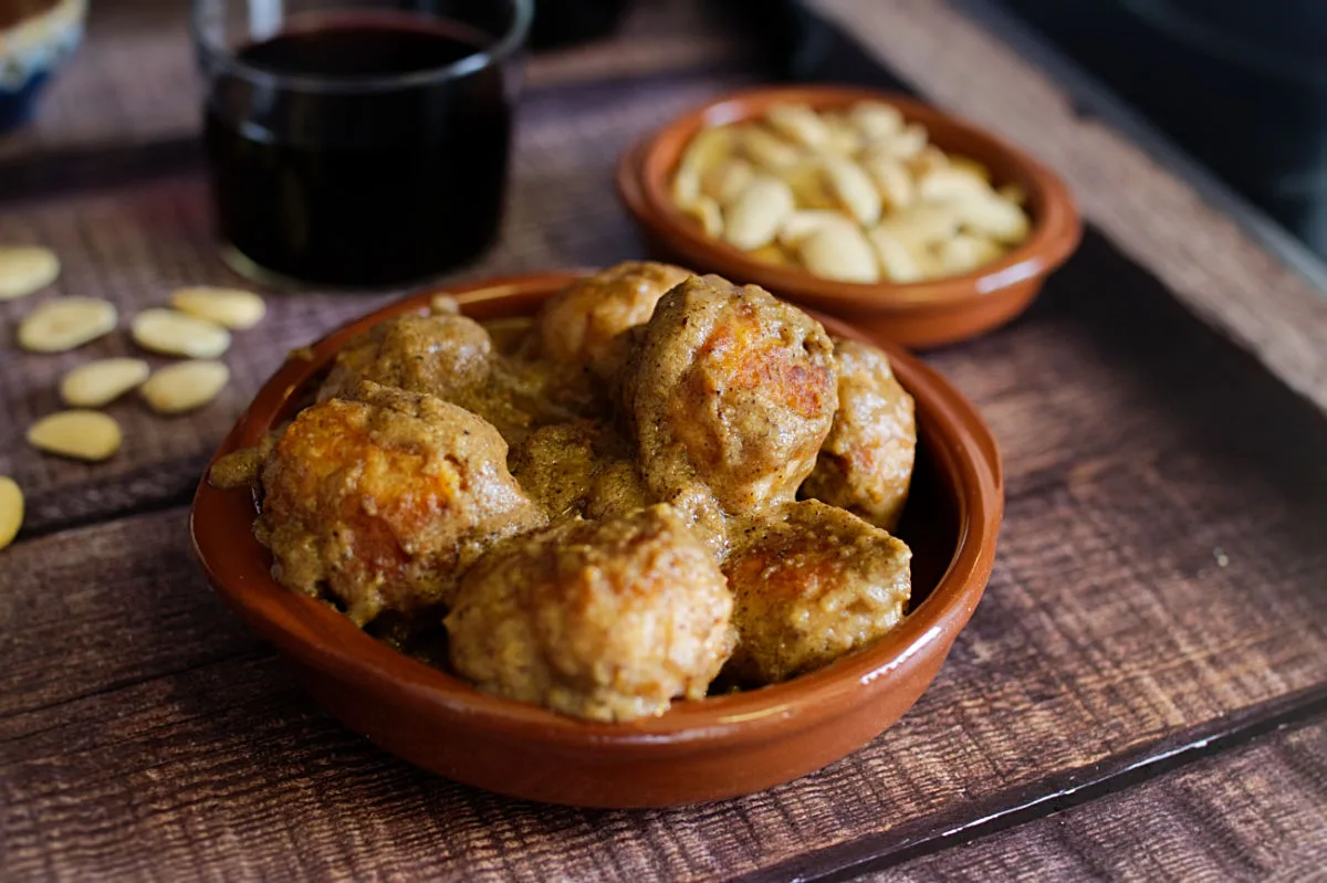 A small tapas serving of chicken meatballs with almond sauce.