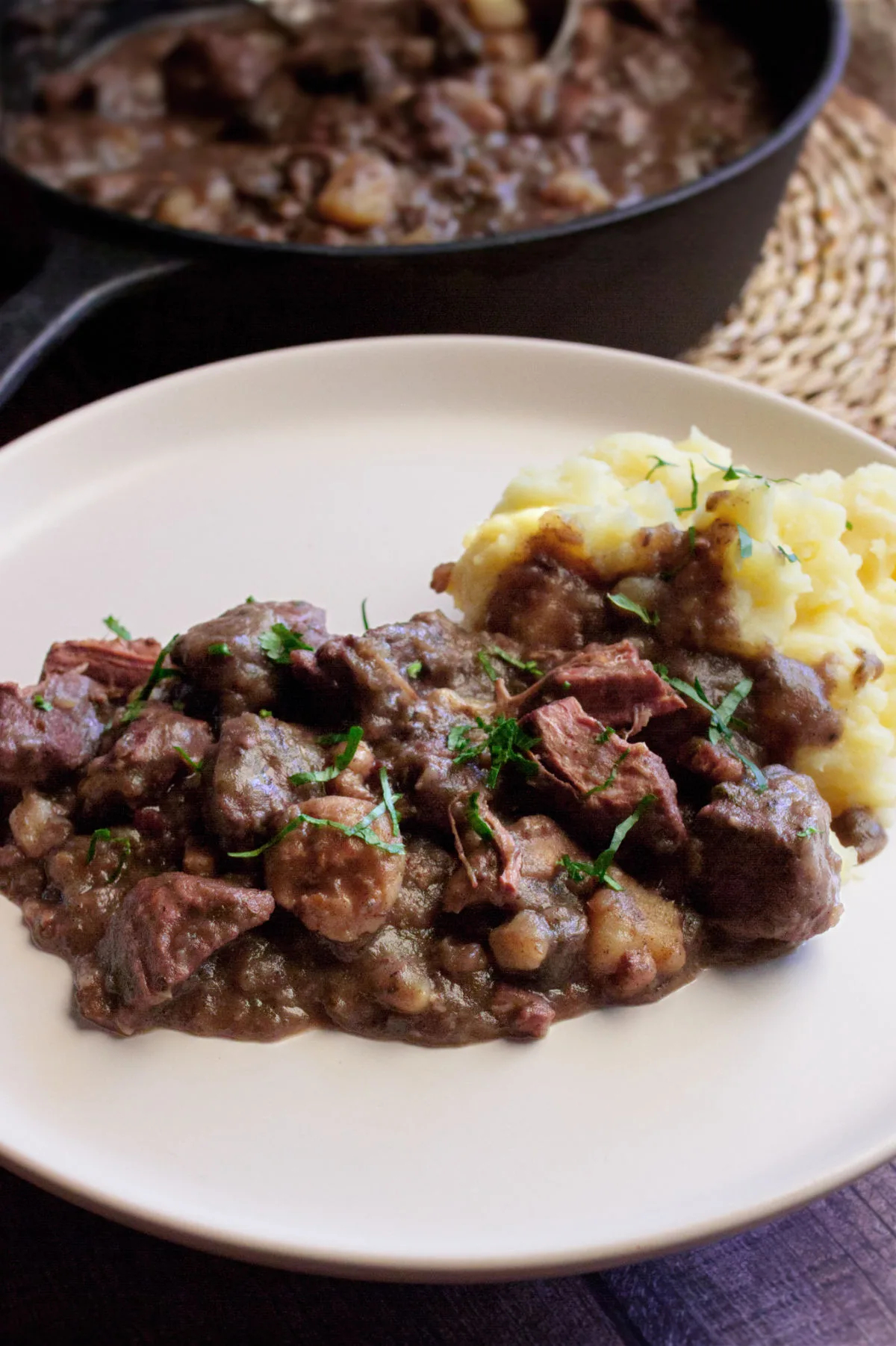 A plate of Catalan style beef stew with some mashed potato.