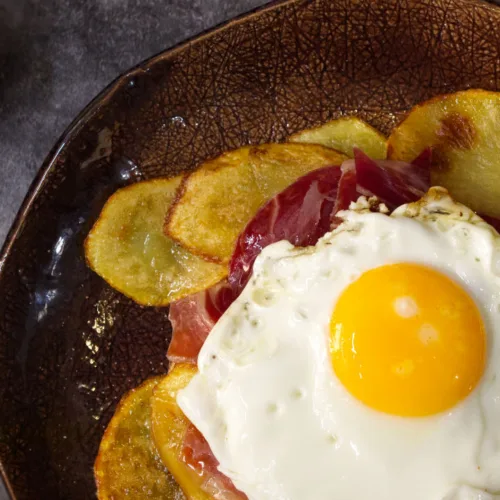 a plate of Spanish-style ham, egg and chips